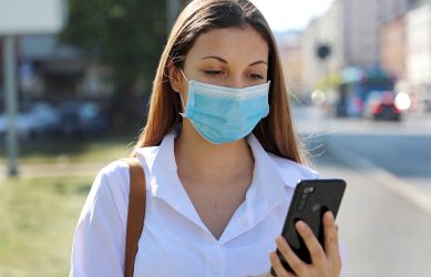 Covid-19,Mobile,Application,Young,Woman,Wearing,Surgical,Mask,Using,Smart