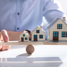 Parsons,Hand,Balancing,Growing,House,Models,On,Wooden,Seesaw