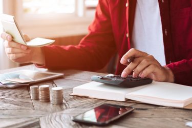 Asian,Man,Working,With,Calculator,To,Calculate,Numbers.,Expenses,Calculator,