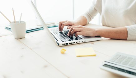 Woman,Sitting,At,Desk,And,Working,At,Computer,Hands,Close