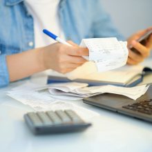 Woman,Using,A,Pen,Writing,On,Bank,Account,Book,While