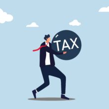 Businessman,Carry,A,Heavy,Burden,With,The,Word,Tax.,A