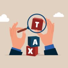 Hands,With,Magnifying,Glass,And,Cubic,On,Stack,With,The